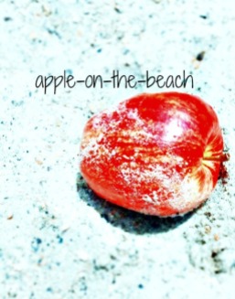Red apple in the sand at the beach